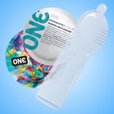 Close-up image of two condom wrappers, one featuring a colorful design and the other displaying text along with the brand name "Condomania." A transparent Free Sample: ONE Pleasure Plus Condom with Pouch (Limit 1) is partially unrolled in front of the wrappers, all set against a light blue background.